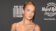 Ellie Thumann poses in front of a gray backdrop in a sparkly silver dress and a slicked-back hairdo.