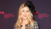 Genie Bouchard poses in a black and white tweed blazer and a black floral hair piece.