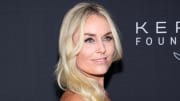 Lindsey Vonn sports her hair in a bright blonde wave and smiles over her shoulder at the camera.