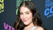 Gigi Robinson poses in a knit dress and a soft wave and smiles for the camera.