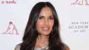 Padma Lakshmi poses in a silver metallic top and a glossy lip.