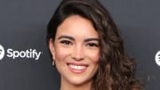 Kyra Santoro poses with her brown curls pulled to the side.