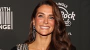 Melissa Wood-Tepperberg sports her hair in a soft curl and smiles widely at the camera.