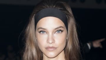 Barbara Palvin wears a black headband in her long brown hair and poses for the camera.