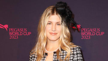 Genie Bouchard poses in a black and white tweed blazer and a black floral hair piece.