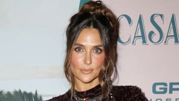 Melissa Wood-Tepperberg poses in a deep burgundy sequined dress and a messy updo.