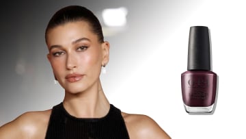 On the left, Hailey Bieber poses in a black halter neck dress and a slicked-back up-do. On the right, there is a bottle of dark burgundy OPI nail polish.