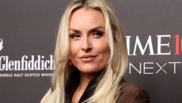 Lindsey Vonn wears a brown suede jacket and smiles off to the side.