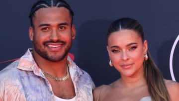 Eric Kendricks and Ally Courtnall pose together on a red carpet and smile for the camera.