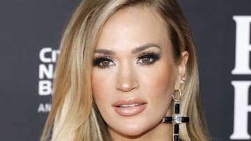 Carrie Underwood sports oversized black diamond cross earrings and poses for the cameras.