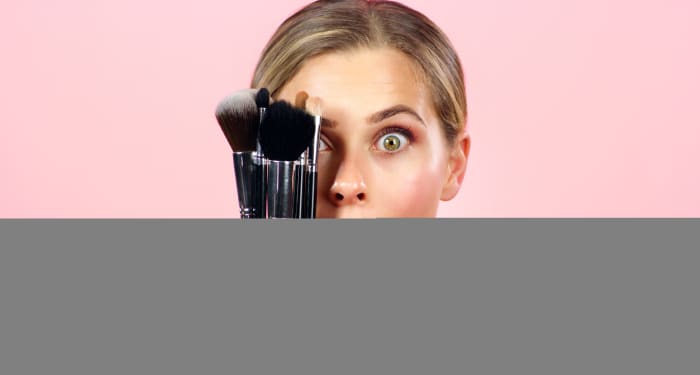 Woman holding makeup brushes.