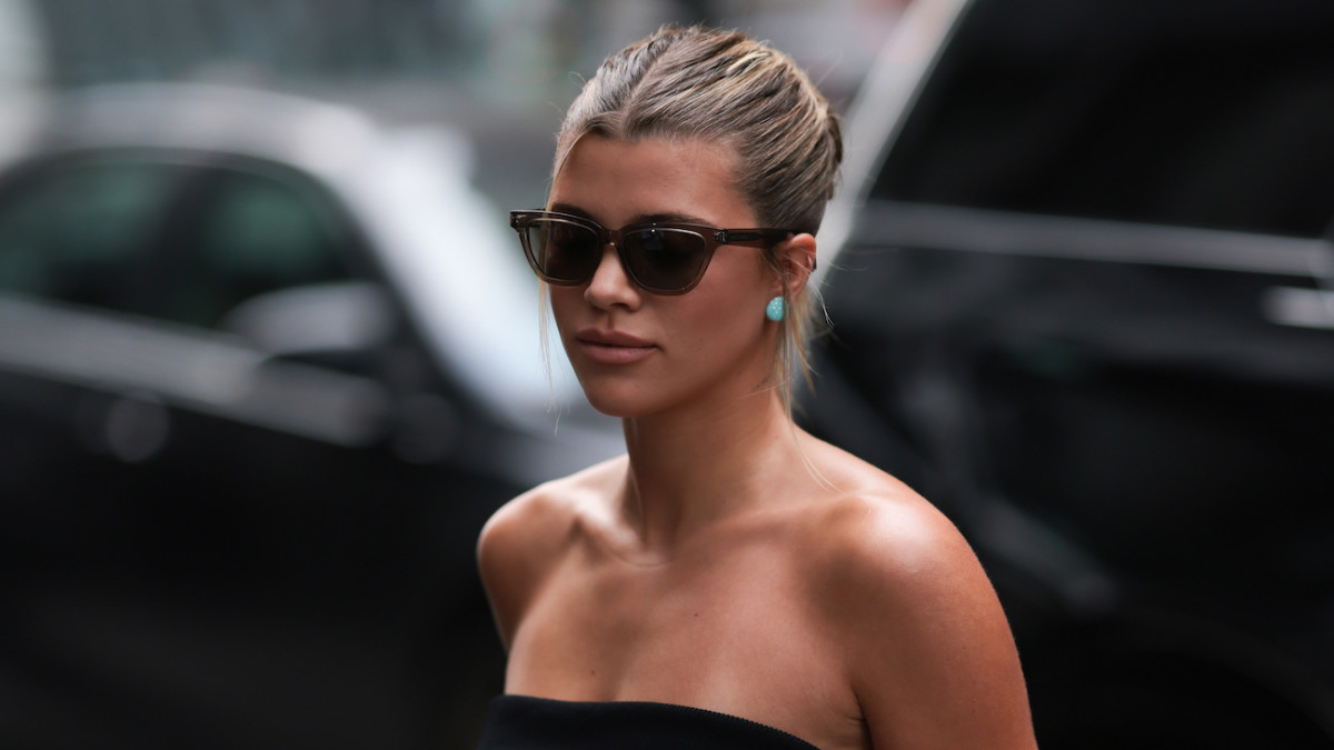 Sofia Richie wears a slicked back bun, sunglasses and a strapless black top for an afternoon out.