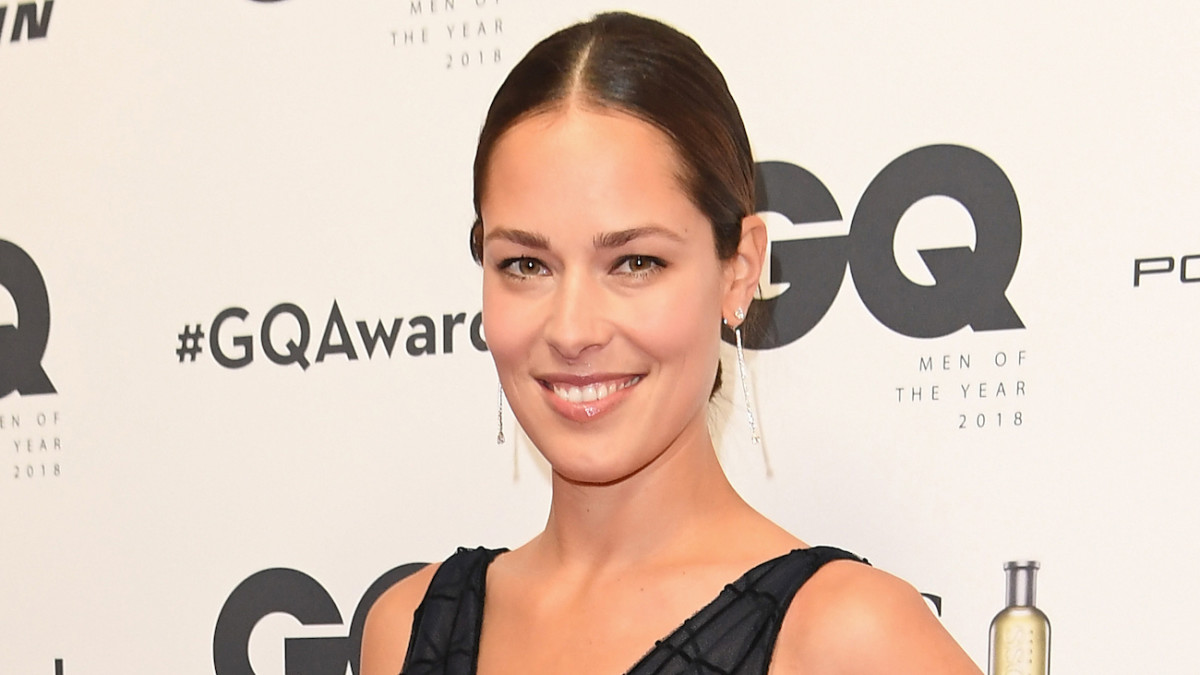Ana Ivanović smiles at the camera, wearing a black V-neck gown and her brown hair slicked-back.