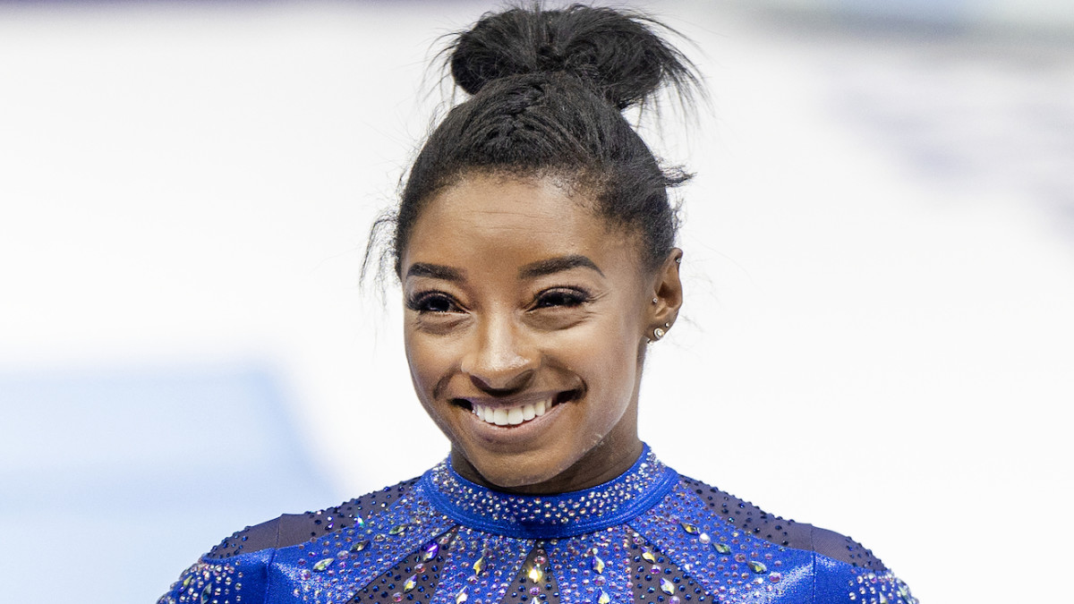 Simone Biles wears a blue sequined leotard and a huge smile during the 2023 Artistic World Gymnastics Championships.