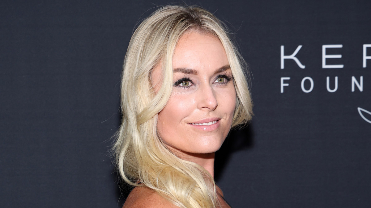 Lindsey Vonn sports her hair in a bright blonde wave and smiles over her shoulder at the camera.