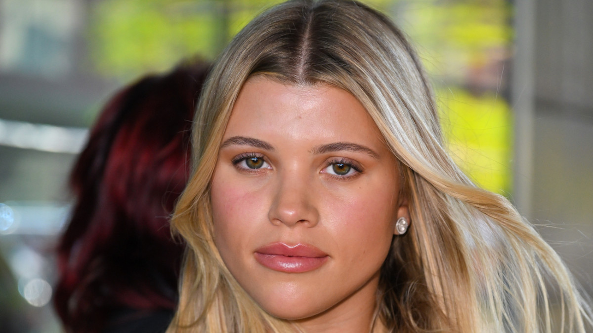 Sofia Richie poses with her dirty blonde hair in a blow out and looks at the camera.